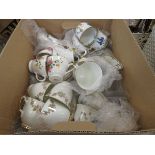 Box containing large amount of floral patterned cups and saucers