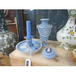 A Wedgwood Jasperware chamber stick, together with a trinket box and cover and an urn shaped vase,