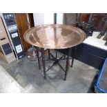 Large circular copper top campaign table on folding base