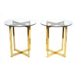 A pair of Hollywood Regency brass cruciform tables with circular glass tops, d. 60 cm each (2)