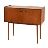 A 1970's and later teak cabinet, the two doors with circular moulded handles, on turned tapering