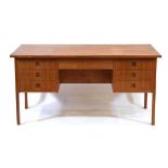 A 1960's Danish teak and crossbanded desk with an arrangement of seven drawers, integral moulded