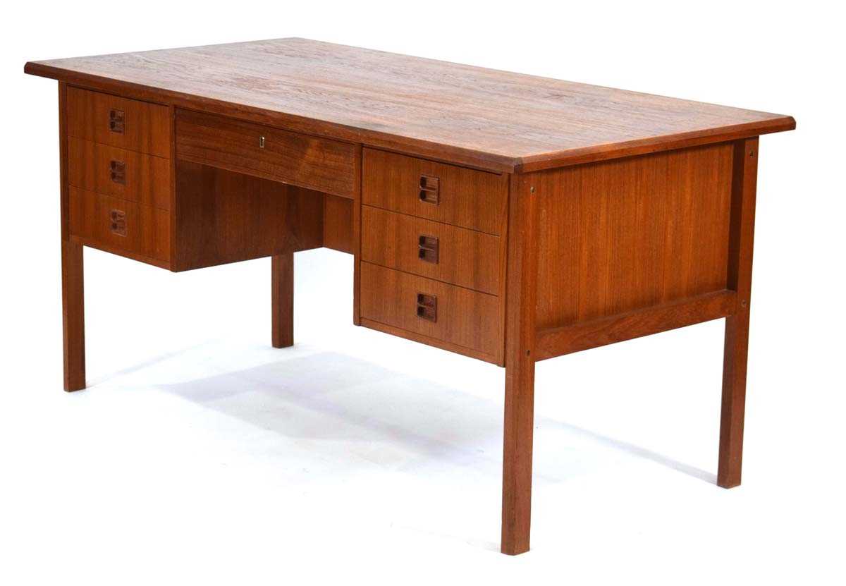 A 1960's Danish teak and crossbanded kneehole desk with an arrangement of seven drawers, the reverse