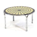 A 1960's circular coffee table with a tortoise-shell design in dark green and yellows, d. 79 cmThe