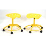 A pair of late 20th century yellow tractor-seat stools