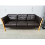 A Danish beech framed three-seater sofa with brown leather upholstery*Sold subject to our Soft