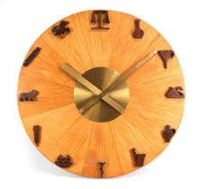 A 1950's circular electric wall clock, the walnut veneered face with brass finished hands and