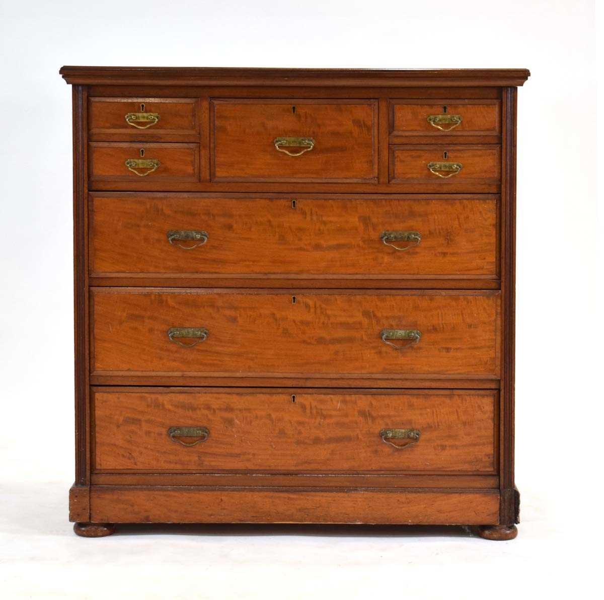 A late 19th century mahogany chest of eight drawers by James Shoolbred & Co., on a plinth base,