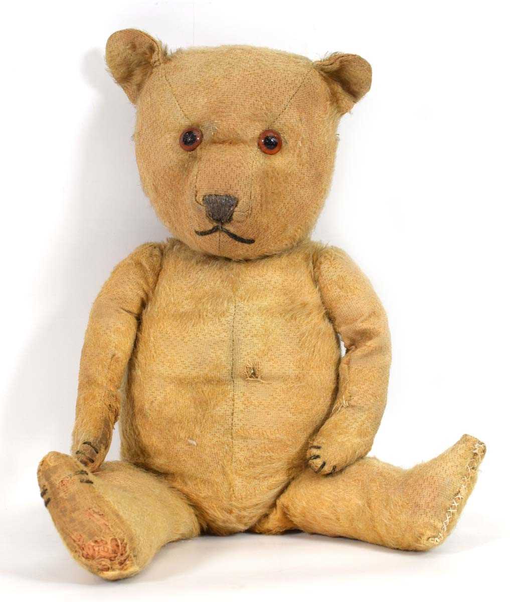 An English early/mid 20th century fully jointed bear with amber/black eyes, l. 47 cm (af)In need