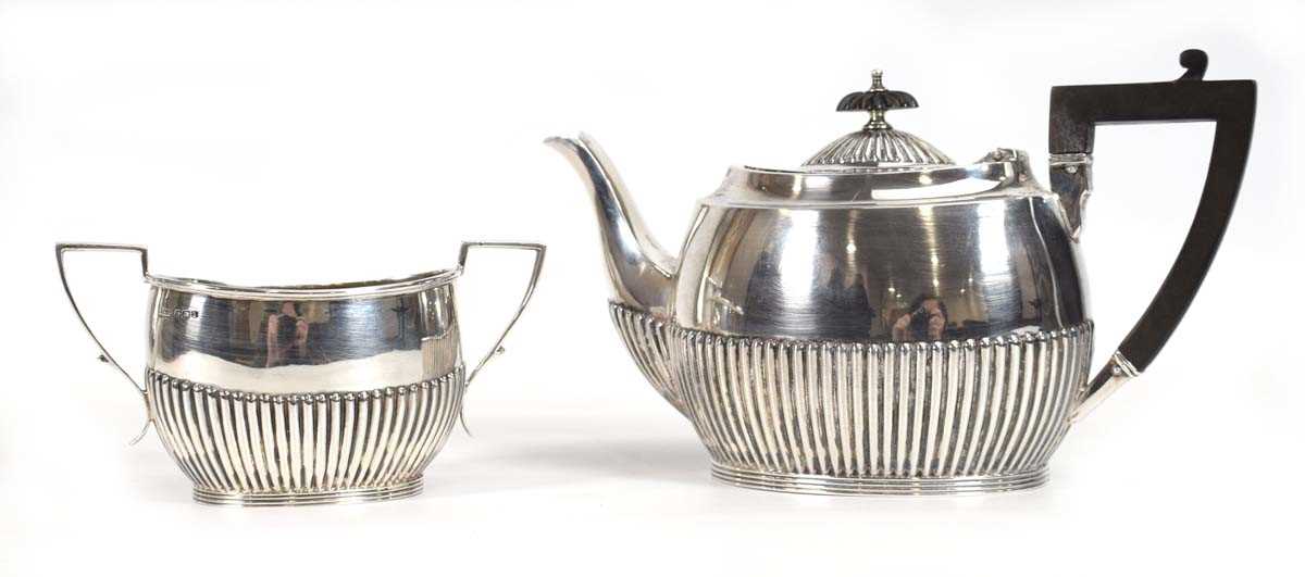 An early 20th century silver bachelors' teapot with gadrooned decoration and a matching two
