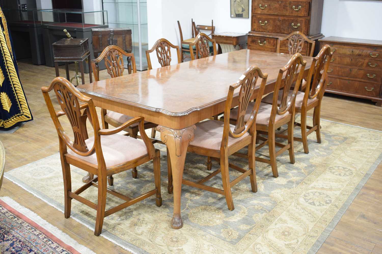 A reproduction walnut dining suite including a table on cabriole legs, 240 x 106 cm, and eight