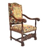 An 18th century style armchair in the Flemish manner, the beech frame with scrolled arms and a