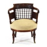 A late 19th century mahogany elbow chair with elaborate foliate, faux trellis and spindle carving,