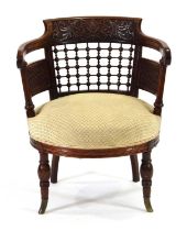 A late 19th century mahogany elbow chair with elaborate foliate, faux trellis and spindle carving,