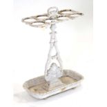 A Victorian white painted cast-iron umbrella and stick stand with eight compartments over a