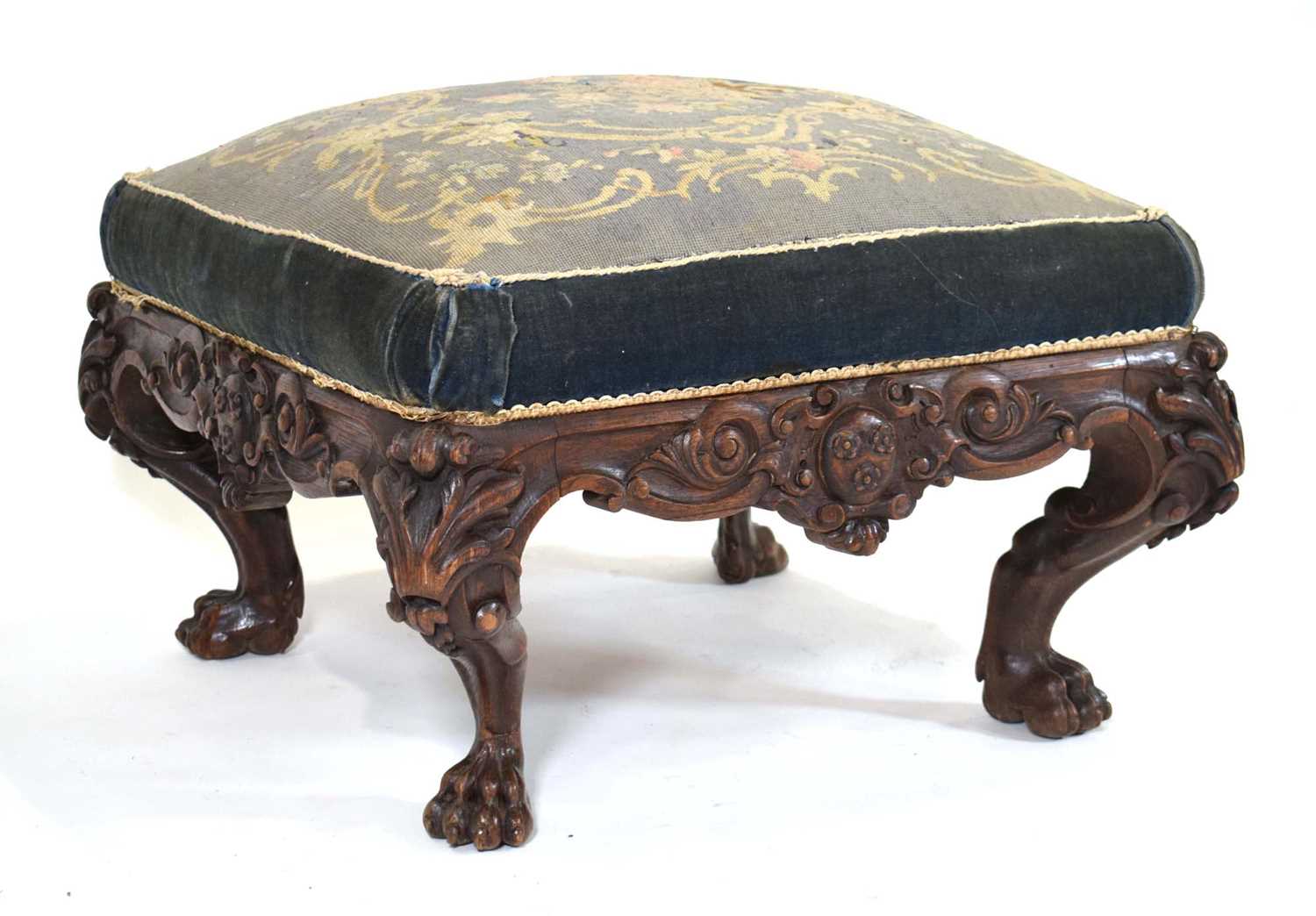 A late 19th century Irish carved oak stool of square form, the seat upholstered with floral