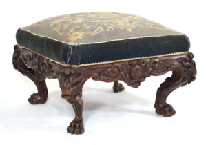 A late 19th century Irish carved oak stool of square form, the seat upholstered with floral