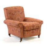 In the manner of Howard & Sons, a late 19th century low open armchair on mahogany turned legs with