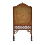 A 19th century walnut and embroidered firescreen with fretwork decoration in the Aesthetic
