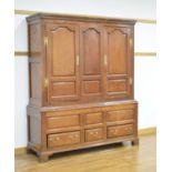 An 18th century oak armoire, the pair of panelled doors over an arrangement of three drawers on