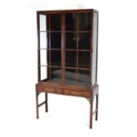 A 20th century mahogany display cabinet, the pair of glazed doors enclosing adjustable shelves