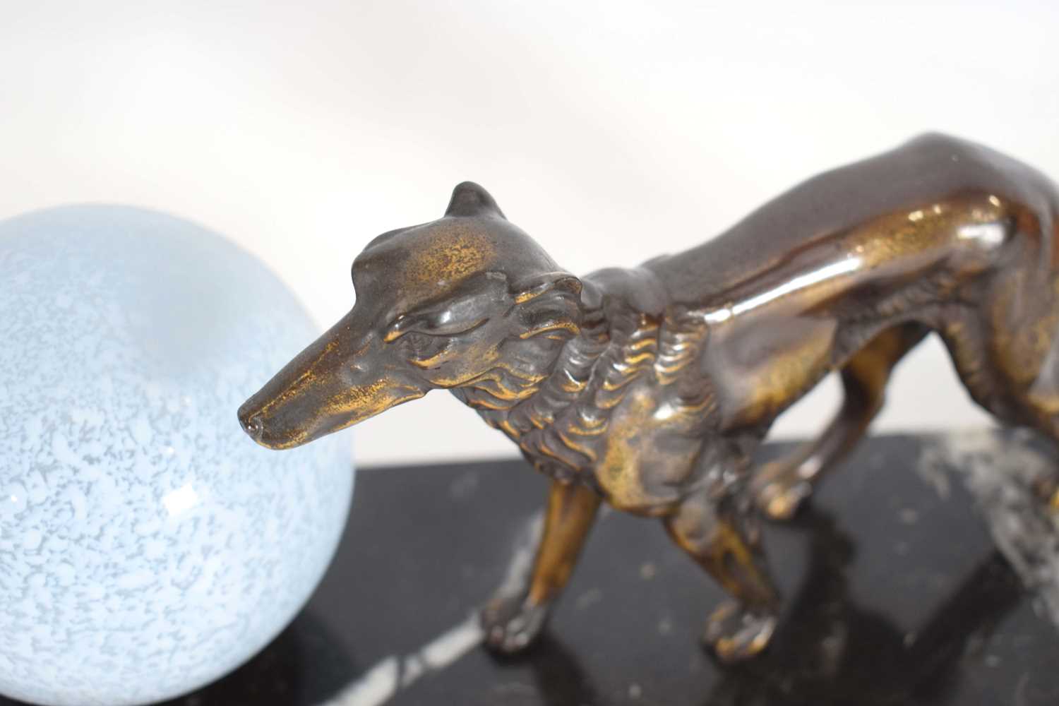 An Art Deco style lamp, the spherical glazed shade flanked by a pair of spelter dogs, on a marble - Image 3 of 3