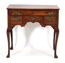 A George II/III and later yew and mahogany lowboy with an arrangement of one long and three short