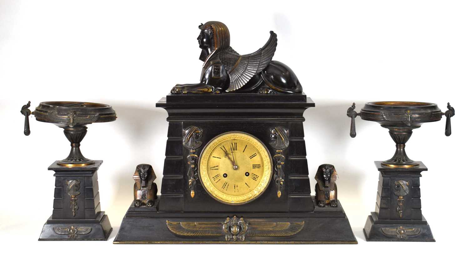 A Victorian 'Egyptian Revival' mantle clock and garnitures, the slate and marble body surmounted and