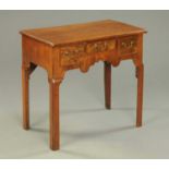 A Georgian walnut lowboy with moulded edges and three frieze drawers over a shaped apron, on