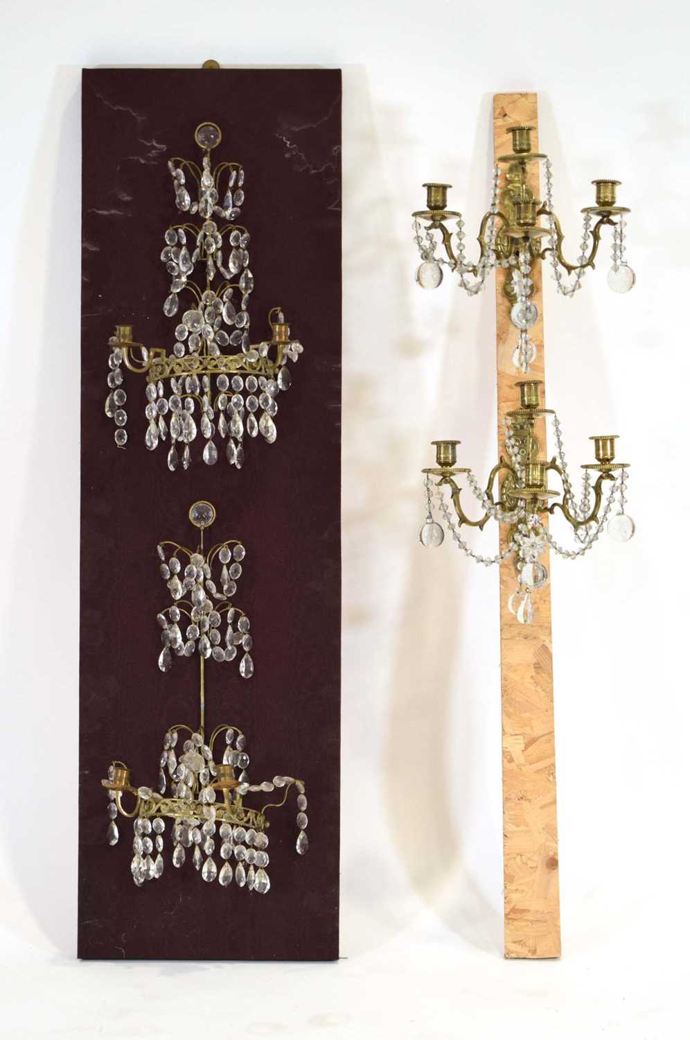 A set of four 20th century brasswork wall sconces with glass lustre droplets, on a pair of watered