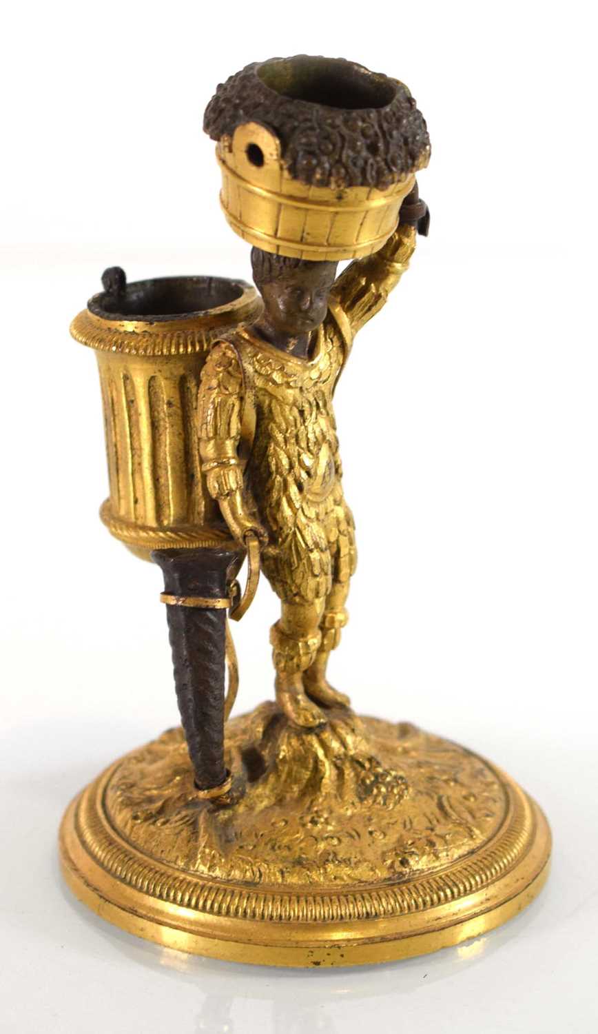 An early 20th century gilt bronze candle holder and vesta modelled as a boy clad in feathers,