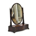 An early 19th century toilet mirror, the oval plate within a matching frame on a serpentine base