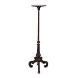 A 19th century mahogany torchère stand with a turned column, acanthus caps and three scrolled