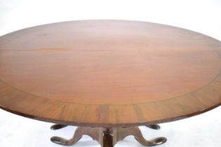 A 19th century mahogany, strung and crossbanded extending dining table of circular form, on two