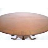 A 19th century mahogany, strung and crossbanded extending dining table of circular form, on two