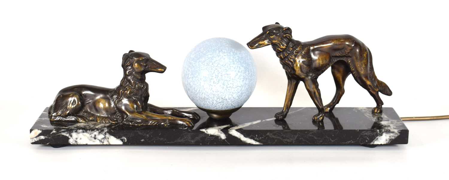 An Art Deco style lamp, the spherical glazed shade flanked by a pair of spelter dogs, on a marble - Image 2 of 3