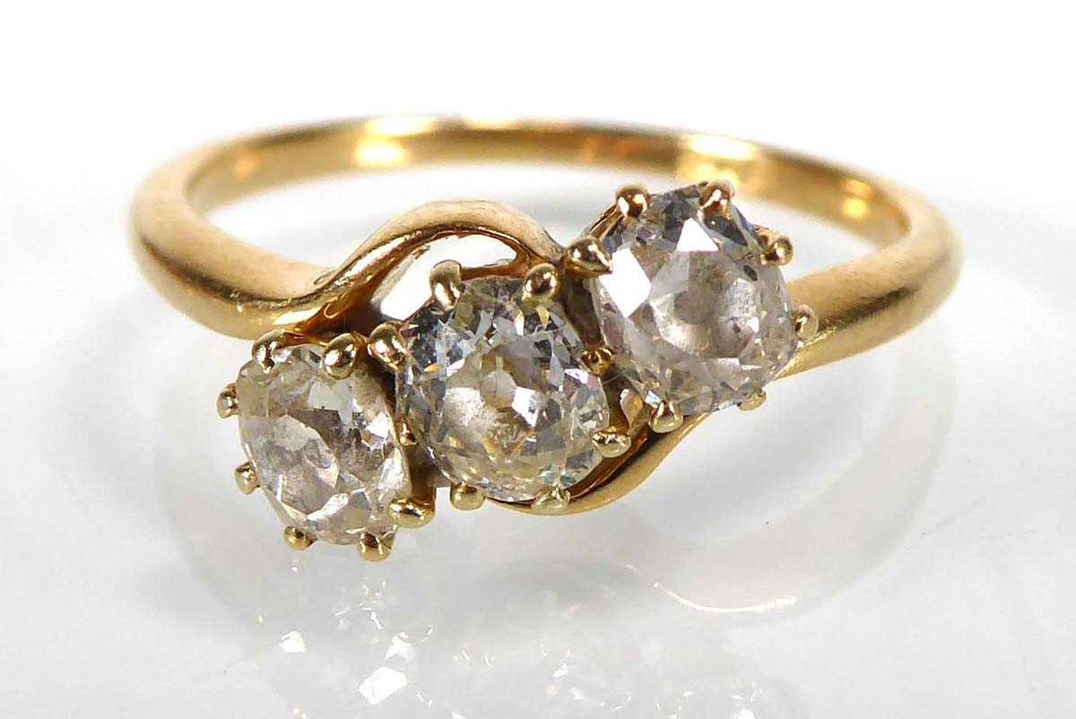 An 18ct yellow gold ring set three graduated old cut diamonds in a crossover setting,central stone