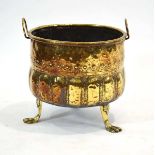 A brass jardinière planter, possibly Dutch, with hoop handles, relief decoration and three claw