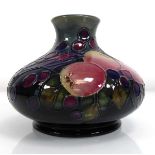 A Moorcroft finches and fruit pattern vase of squat form, h. 10 cm