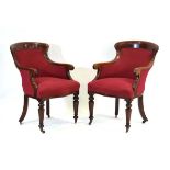 A pair of Victorian mahogany club carvers or armchairs upholstered in red with serpentine seats,