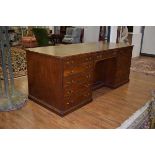 An unusual early 20th century mahogany partner's desk, the three-section gilded tooled leather