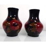 A pair of Moorcroft leaf and berry pattern vases of slender bellied form, h. 17 cm (2)Please see the