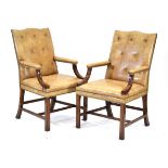 A pair of George III style mahogany and buttoned tan leather library armchairs