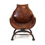A 19th century mahogany and brown leather club armchair on a carved X-frame bearing a mask of a