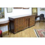 An 18th century oak dresser base with panelled and chamfered sides, the pair of central cupboard