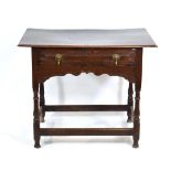 A late 17th century oak lowboy, the chamfered surface over a single frieze drawer and shaped