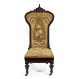 A late 19th century needlework and ebonised Prie Dieu chair on turned legs with castors