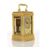 A late 19th century French miniature carriage clock in a intricately engraved brass and five-glass