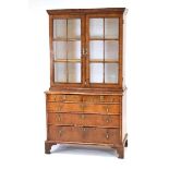 A George I/II walnut bookcase over chest, the pair of glazed doors enclosing two shelves, the base