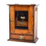 An early 20th century oak smoker's cabinet with a glazed door over a drawer, h. 39 cm, the